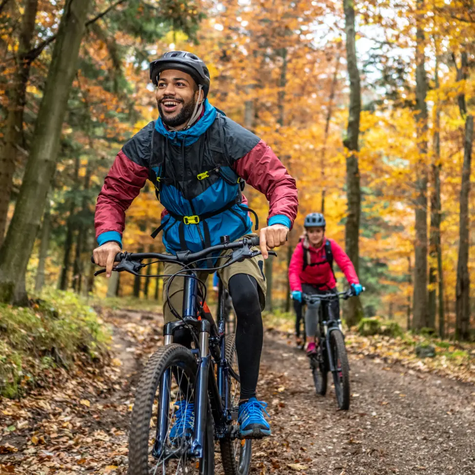 Man and woman riding mountain bikes in forest
