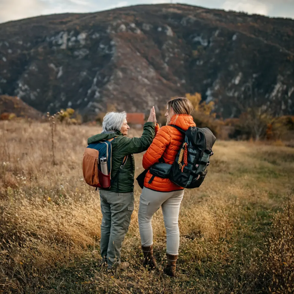 Senior women and her granddaughter hiking on mountain, walking through forest