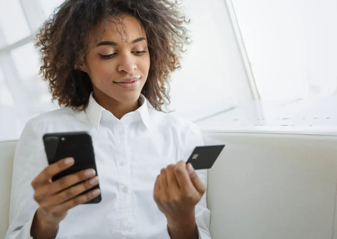 young female with cellphone and credit card