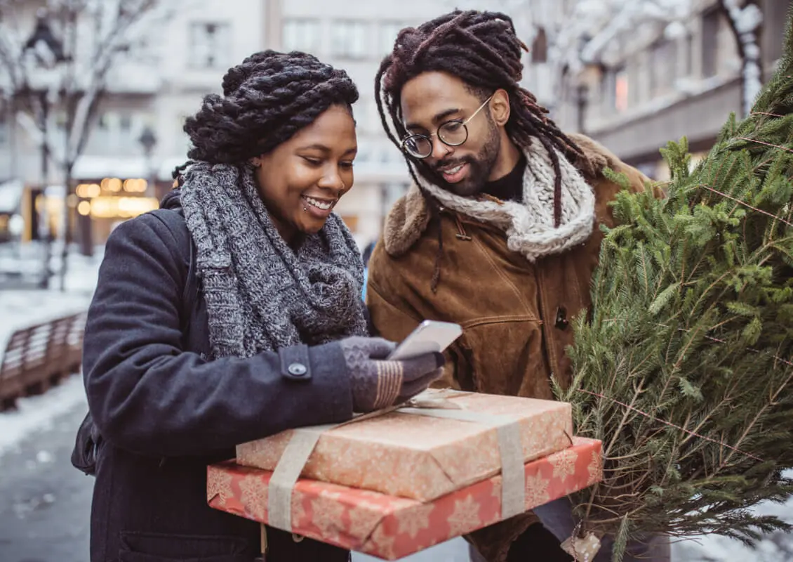 couple outside with gifts and small tree