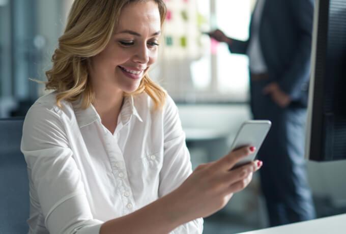 young woman smiling and viewing cellphone