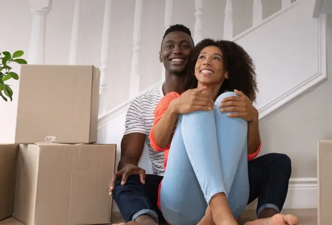 young couple in new home with packing boxes