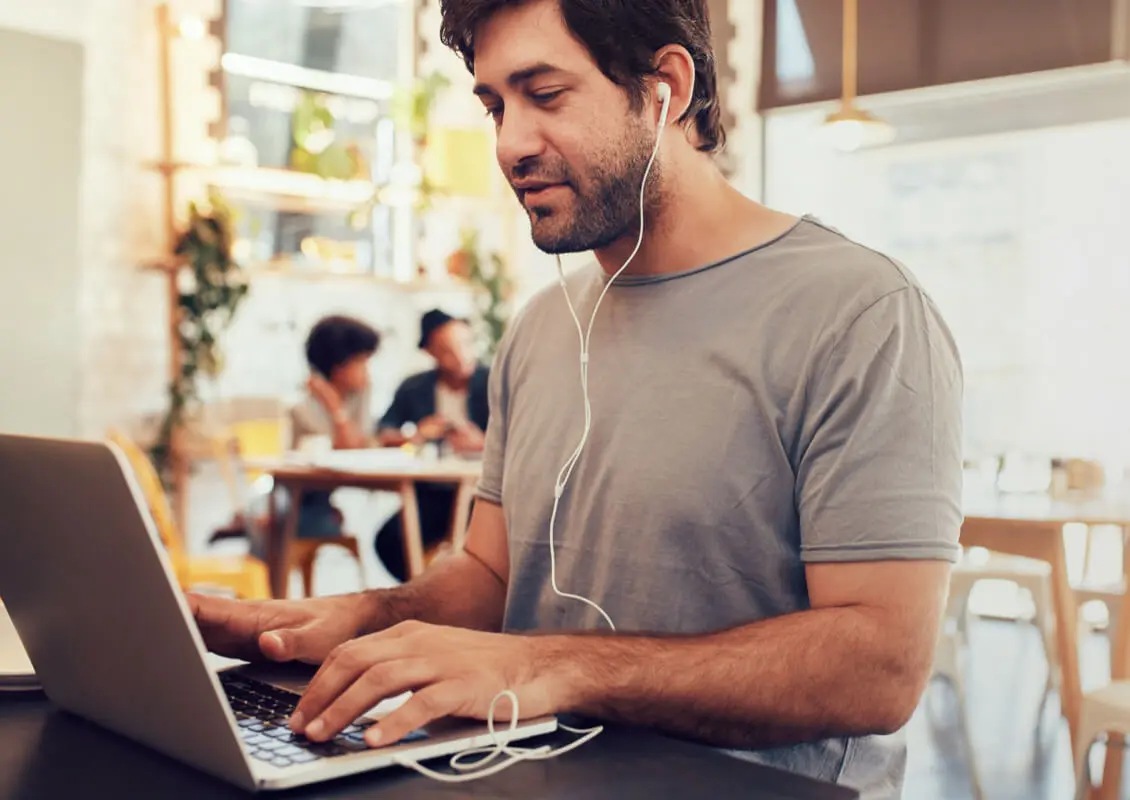 man working on laptop using headphones