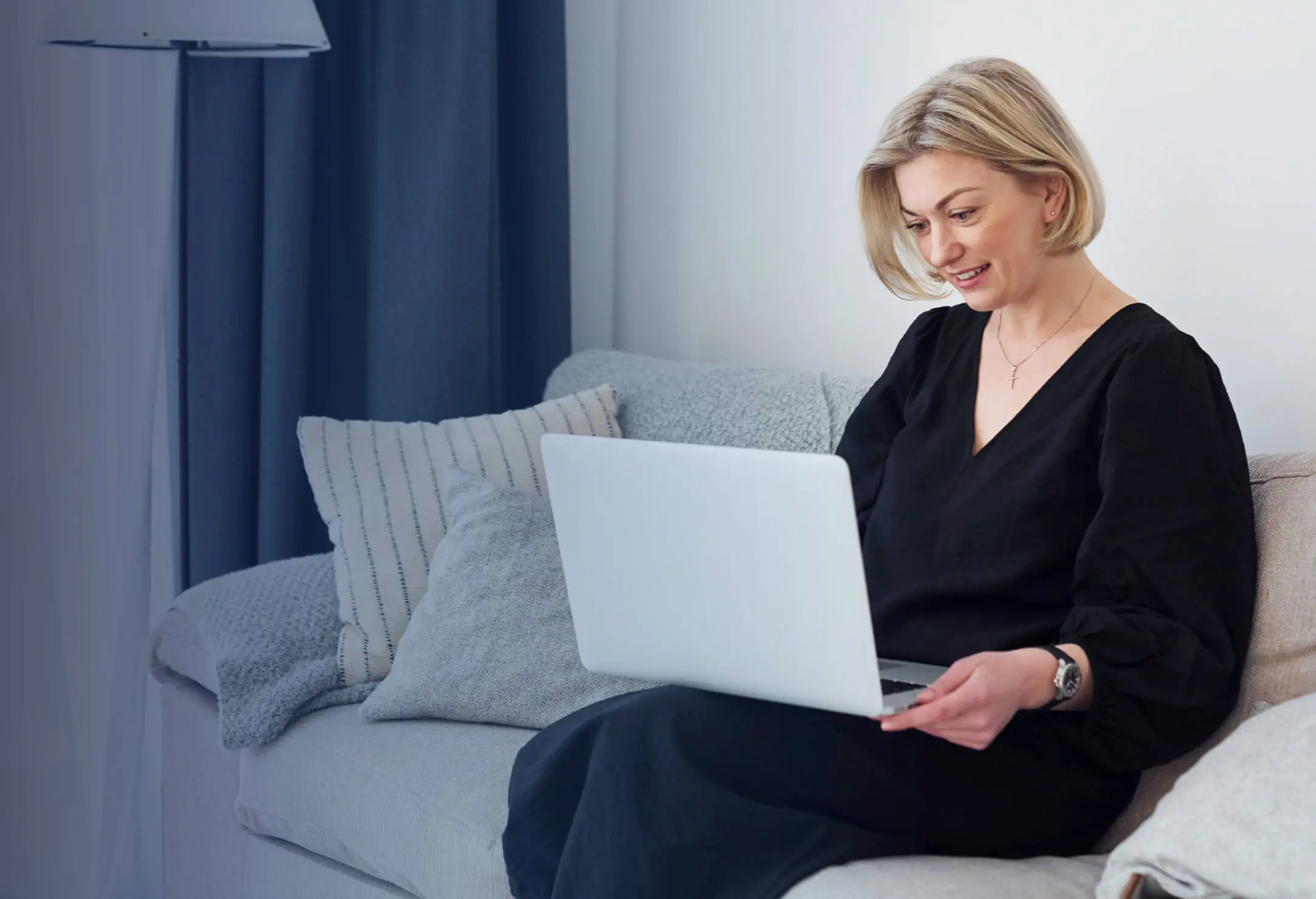 woman sitting on couch with open laptop