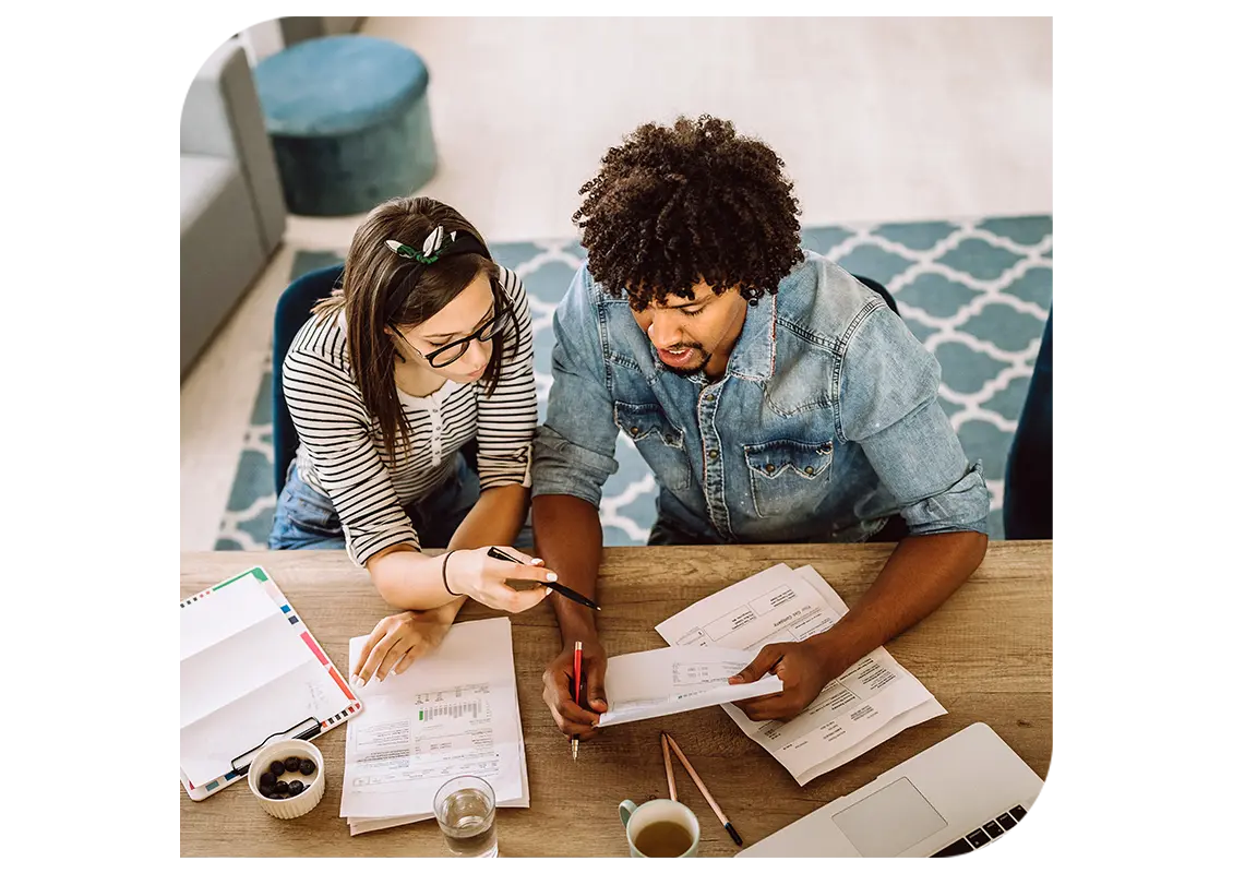 Two people looking through invoices together.