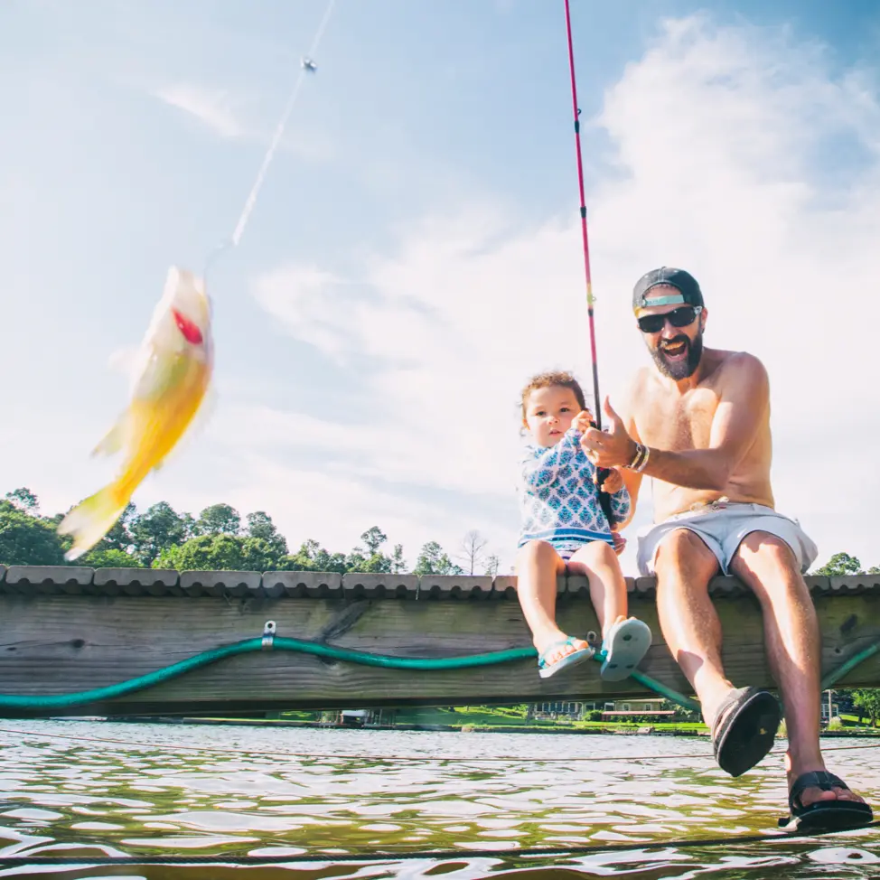 Father and daughter fishing off a dock