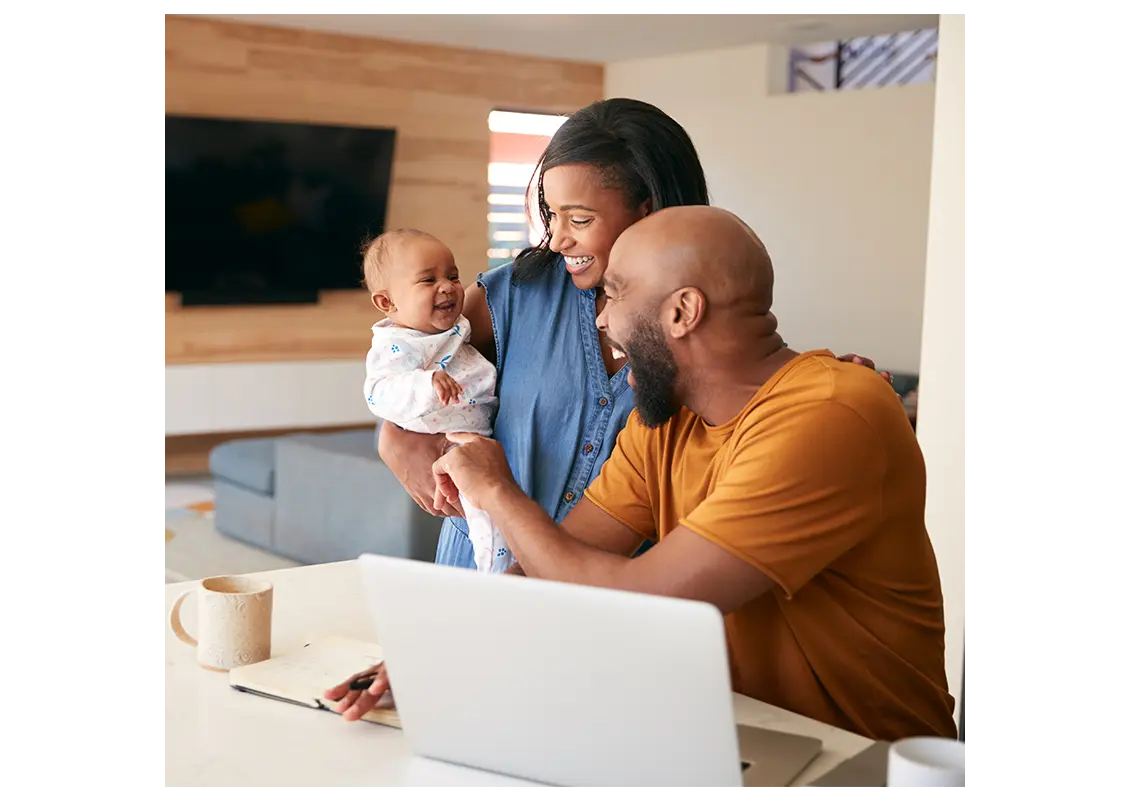 African American family with baby daughter using laptop