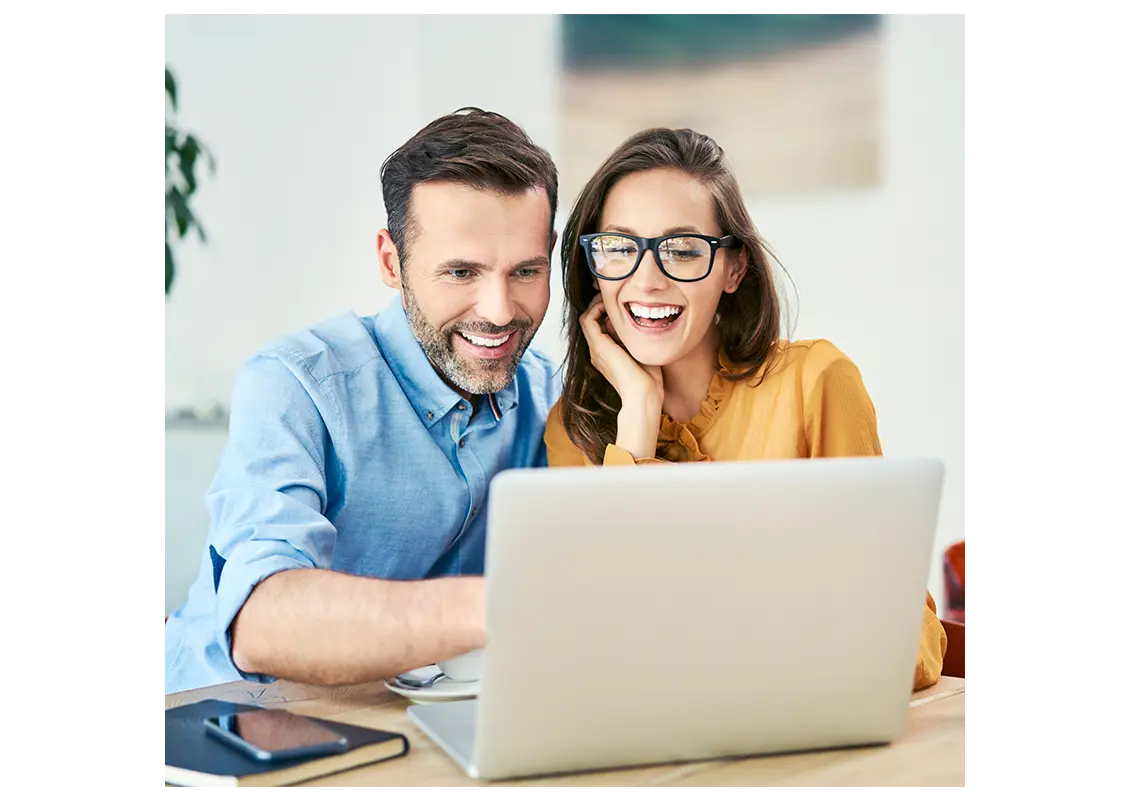 cheerful couple using laptop together