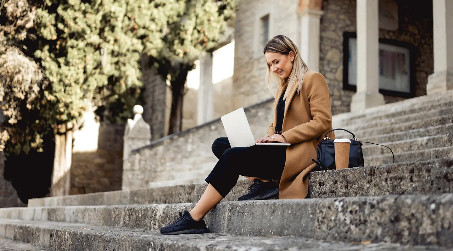 Young woman on steps of building on college campus