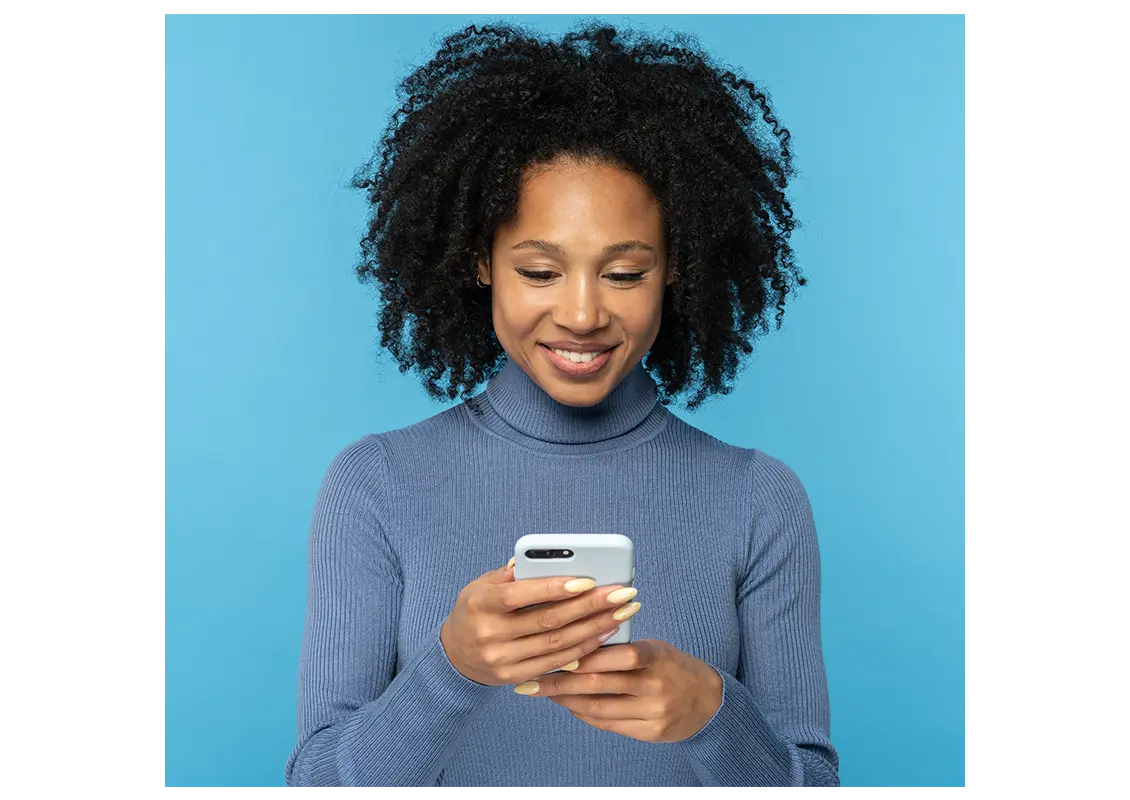 Millennial woman with curly hair using mobile phone
